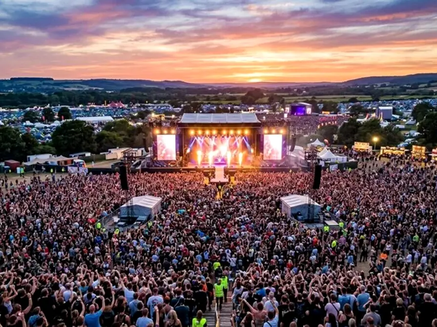 Luftbild einer Open-Air-Bühne mit Publikum bei Sommerlicht.