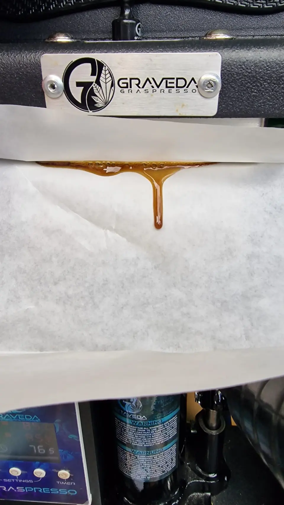 Graveda-Rosinpresse mit Presspapier und austretendem Rosin.